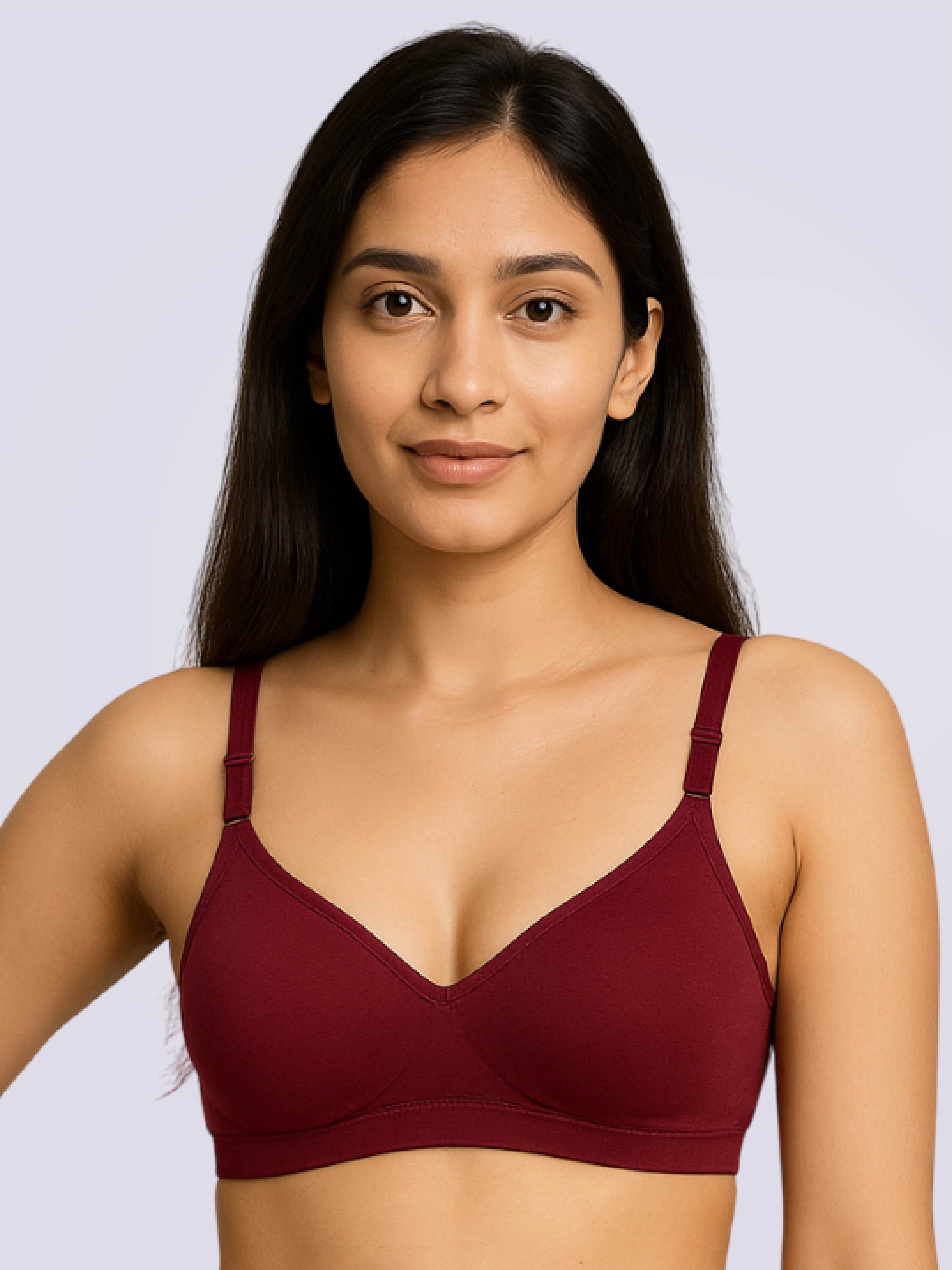 Woman wearing a maroon bralette against a light gray background